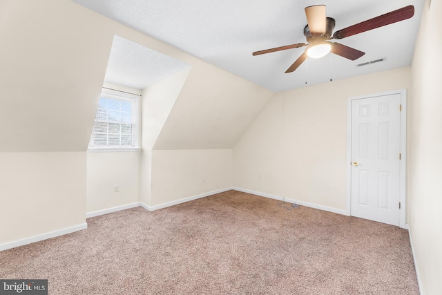 bonus room featuring a ceiling fan, vaulted ceiling, visible vents, carpet floors, and baseboards