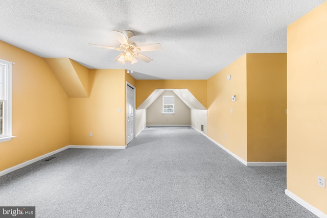 bonus room featuring visible vents, ceiling fan, carpet flooring, and a textured ceiling