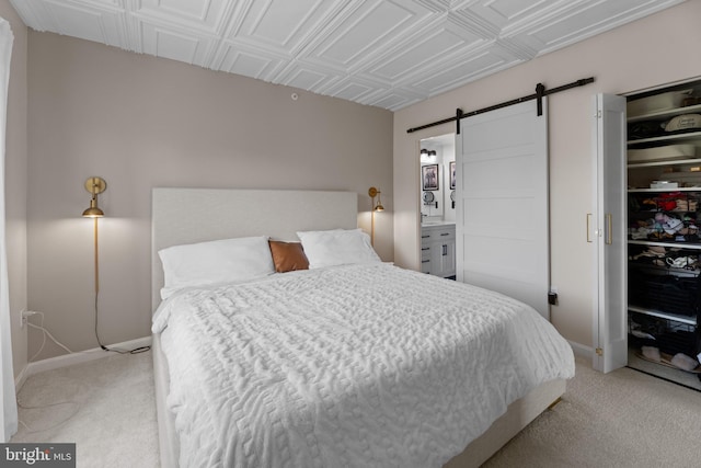 bedroom with a closet, baseboards, a barn door, an ornate ceiling, and light colored carpet