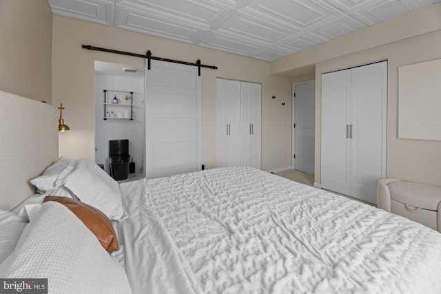 bedroom featuring two closets, an ornate ceiling, and a barn door