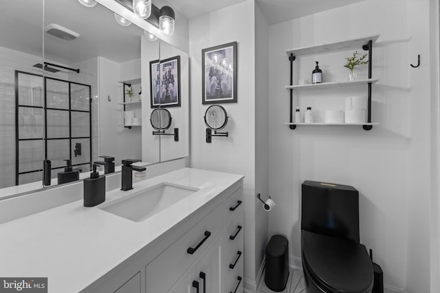 full bathroom with baseboards, tiled shower, and vanity