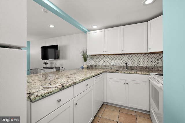 13500 Coastal Hwy Unit 201, Ocean City, MD 21842 - kitchen with light tile patterned floors, white cabinets, a sink, white appliances, and light stone countertops