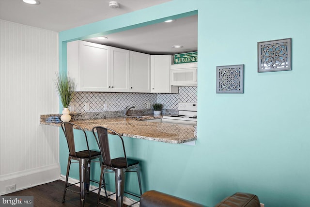 13500 Coastal Hwy Unit 201, Ocean City, MD 21842 - kitchen featuring a sink, a kitchen breakfast bar, white appliances, white cabinetry, and light stone countertops
