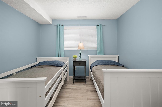 13500 Coastal Hwy Unit 201, Ocean City, MD 21842 - bedroom featuring visible vents, a textured ceiling, baseboards, and wood finished floors