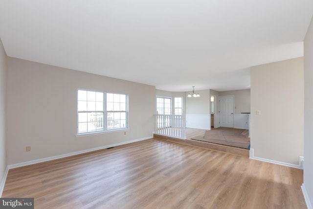 1825 Hessian Dr, Williamstown, NJ 08094 - unfurnished living room with baseboards, light wood-type flooring, and a notable chandelier