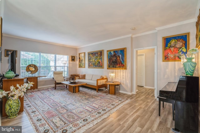 living area featuring light wood-style flooring, baseboards, and crown molding