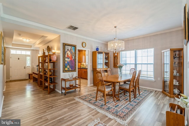 dining area featuring light wood finished floors, baseboards, and a chandelier