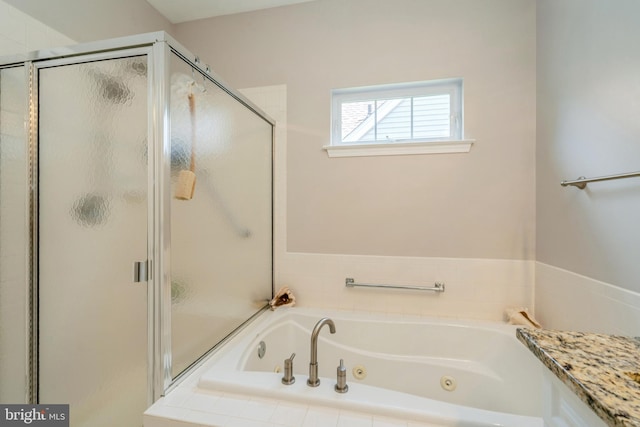 bathroom featuring a tub with jets and a shower stall