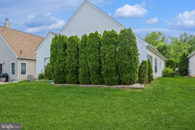 view of property exterior featuring a lawn and central AC