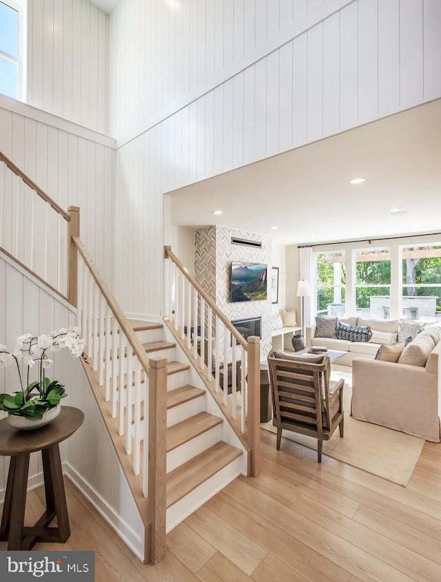 1201 Chesapeake View Dr, Middletown, DE 19709 - staircase with a tiled fireplace, a high ceiling, and wood finished floors