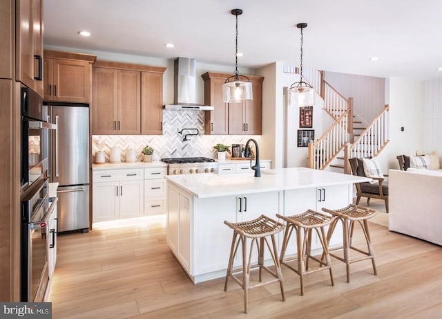 1201 Chesapeake View Dr, Middletown, DE 19709 - kitchen featuring light countertops, wall chimney exhaust hood, stainless steel appliances, and light wood-type flooring