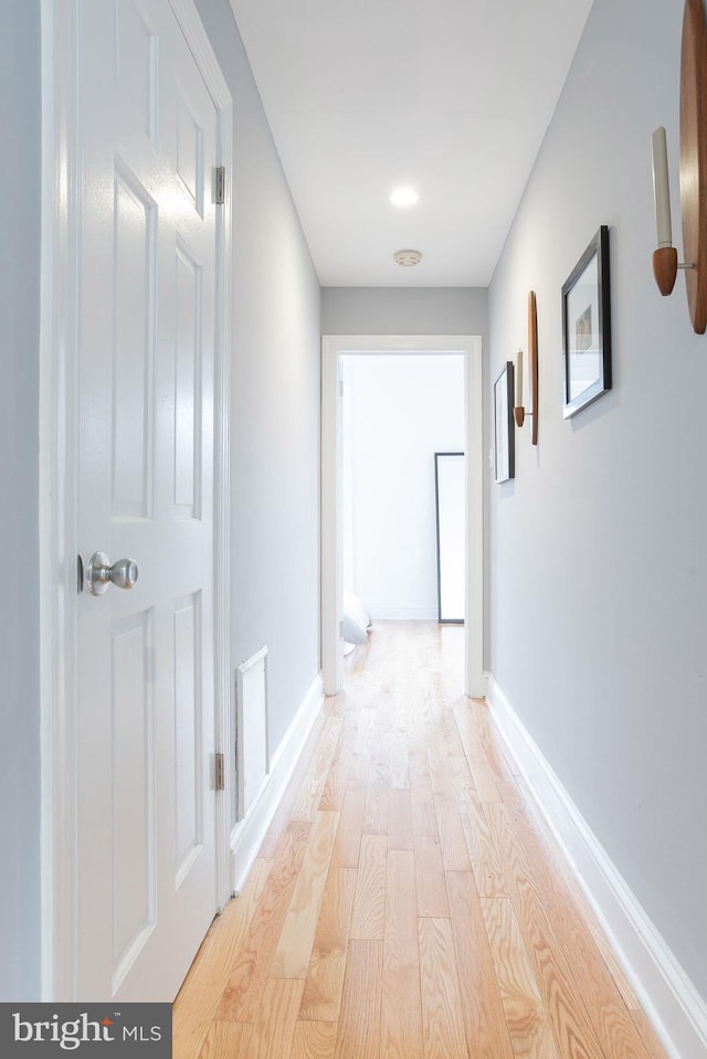 hallway with light wood-style flooring and baseboards