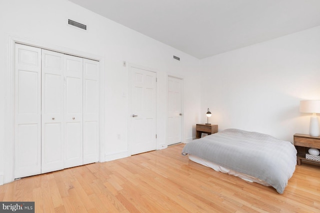 bedroom with light wood-style flooring and visible vents