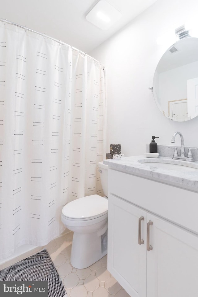 bathroom with tile patterned floors, vanity, and toilet
