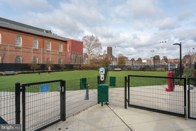 view of gate with fence and a lawn