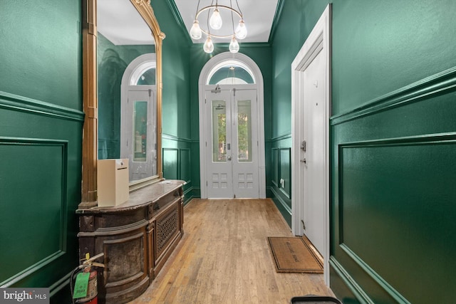 foyer entrance featuring a wainscoted wall, wood finished floors, and a decorative wall