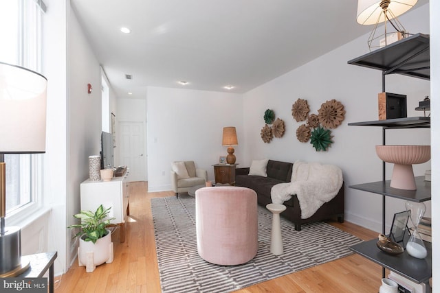 living room with recessed lighting, visible vents, light wood finished floors, and baseboards