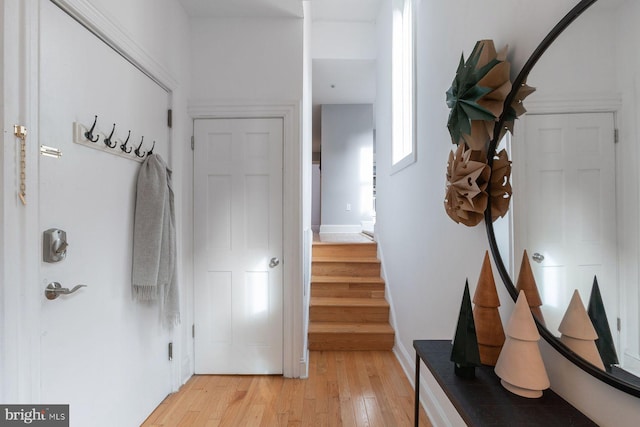interior space featuring baseboards, stairs, and light wood-style flooring