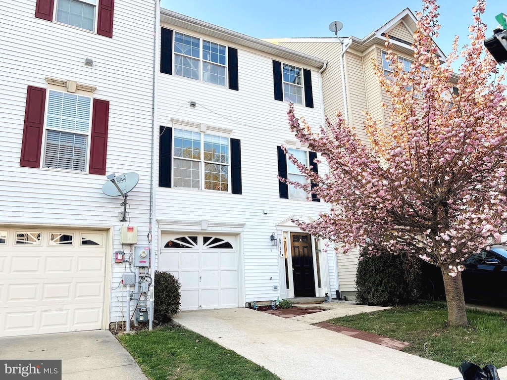 townhome / multi-family property with an attached garage and concrete driveway