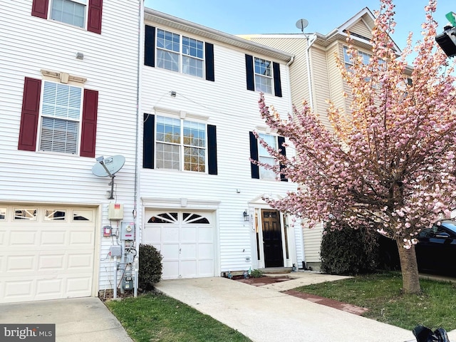 townhome / multi-family property with an attached garage and concrete driveway