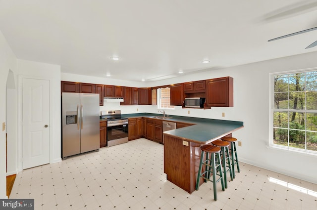 2208 Quarry Rd, Bunker Hill, WV 25413 - kitchen featuring a peninsula, dark countertops, light floors, a sink, and appliances with stainless steel finishes