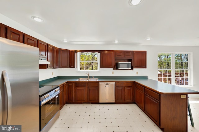 2208 Quarry Rd, Bunker Hill, WV 25413 - kitchen featuring a healthy amount of sunlight, a sink, a peninsula, under cabinet range hood, and stainless steel appliances
