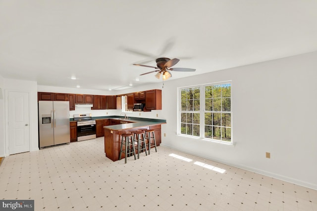 2208 Quarry Rd, Bunker Hill, WV 25413 - kitchen with ceiling fan, appliances with stainless steel finishes, a peninsula, light floors, and under cabinet range hood