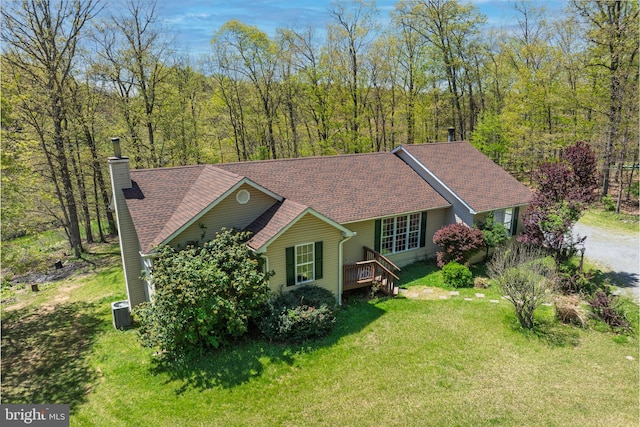 2208 Quarry Rd, Bunker Hill, WV 25413 - view of front of property with a shingled roof, a front yard, a view of trees, a chimney, and cooling unit