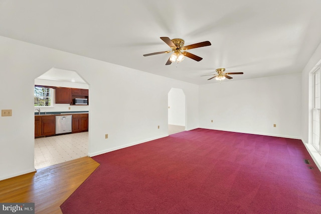 2208 Quarry Rd, Bunker Hill, WV 25413 - unfurnished living room with a ceiling fan, visible vents, arched walkways, baseboards, and carpet