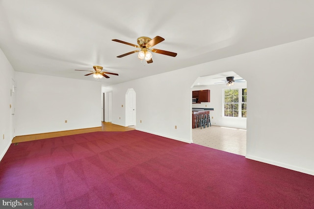 2208 Quarry Rd, Bunker Hill, WV 25413 - unfurnished living room with carpet flooring, a ceiling fan, baseboards, and arched walkways
