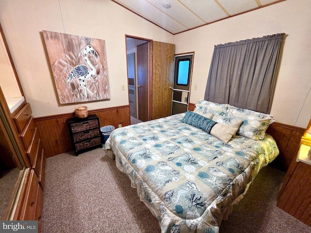 carpeted bedroom with wood walls, wainscoting, and lofted ceiling