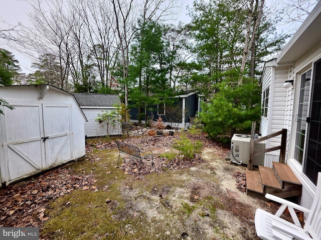 view of yard featuring ac unit, an outbuilding, and a shed