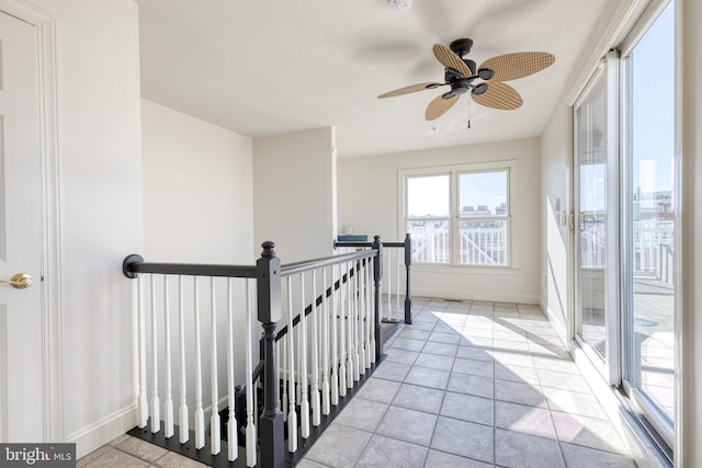 hall featuring an upstairs landing and baseboards