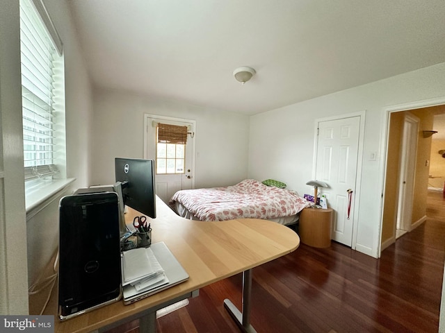 bedroom with dark wood finished floors and baseboards