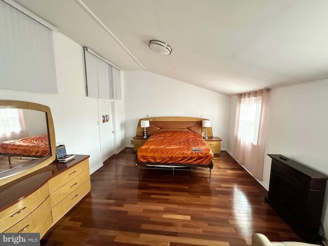 bedroom with dark wood-style floors and vaulted ceiling