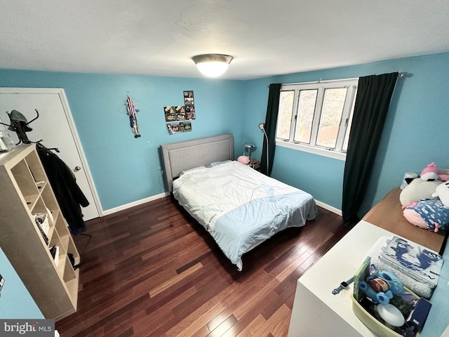 bedroom featuring dark wood-style flooring and baseboards