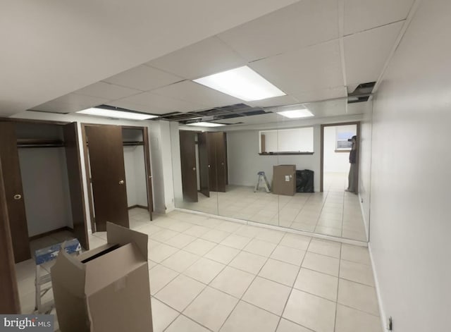 finished below grade area featuring a drop ceiling