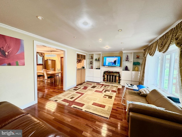 living room with hardwood / wood-style floors, recessed lighting, crown molding, and baseboards