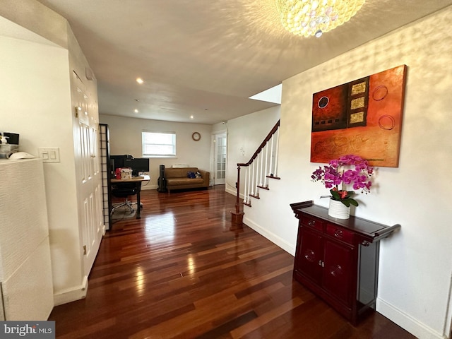 hallway with an inviting chandelier, baseboards, stairs, and wood-type flooring