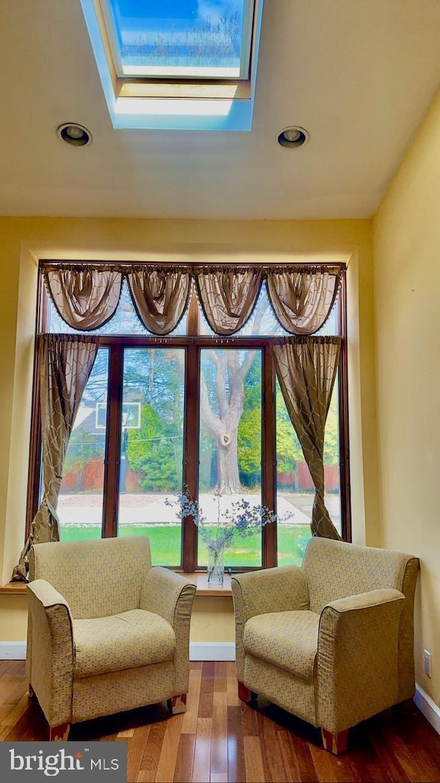 sitting room with a skylight, hardwood / wood-style floors, recessed lighting, and baseboards