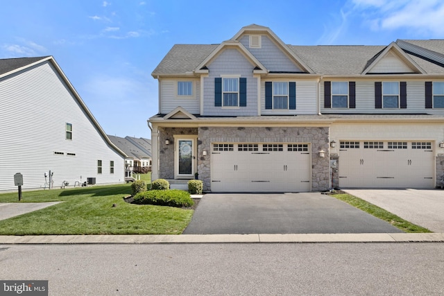 view of property with roof with shingles, stone siding, a garage, aphalt driveway, and a front yard