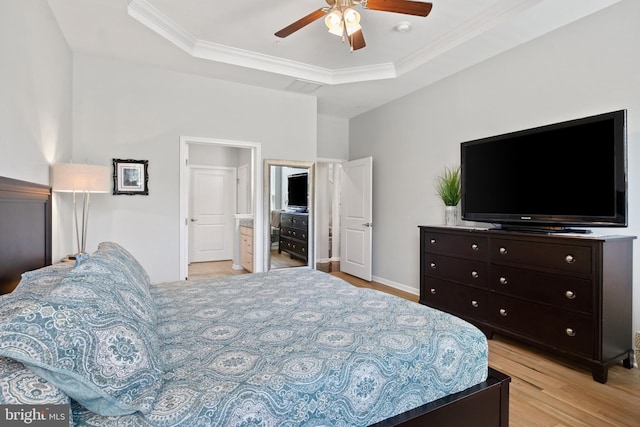 bedroom featuring ceiling fan, a raised ceiling, baseboards, light wood finished floors, and ornamental molding