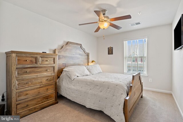 bedroom featuring baseboards, ceiling fan, light carpet, and visible vents