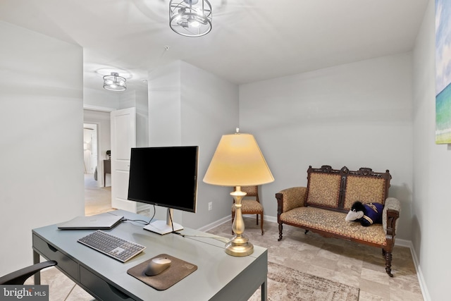 office featuring baseboards and stone finish floor