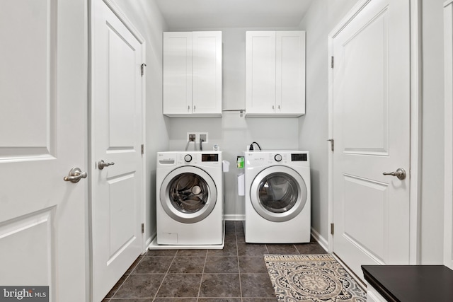laundry room with cabinet space, dark tile patterned flooring, baseboards, and washing machine and clothes dryer