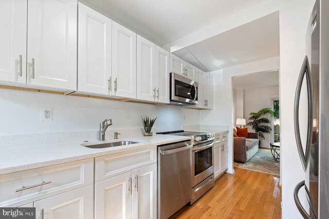 14311 Astrodome Dr Unit 6, Silver Spring, MD 20906 - kitchen with stainless steel appliances, a sink, white cabinets, light wood finished floors, and light stone counters