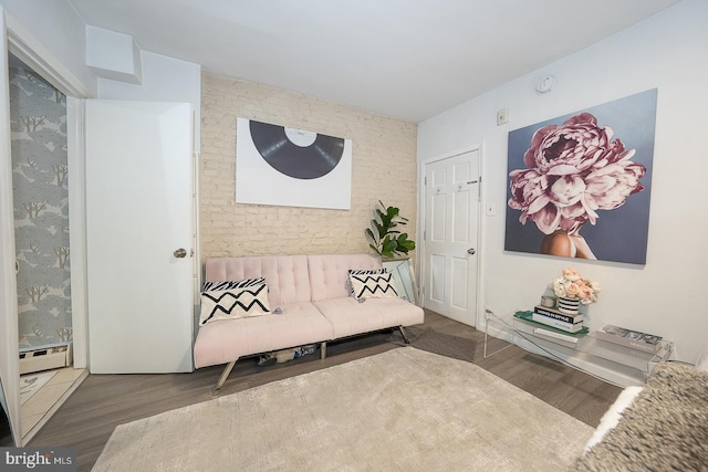 sitting room featuring a baseboard heating unit and wood finished floors