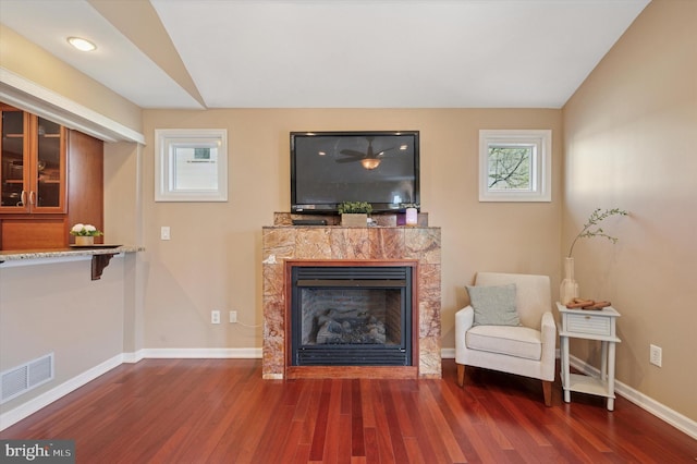 sitting room featuring baseboards, a healthy amount of sunlight, wood finished floors, and visible vents