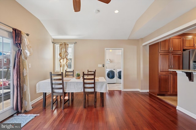 dining area featuring vaulted ceiling, dark wood-style floors, washer and clothes dryer, and a ceiling fan