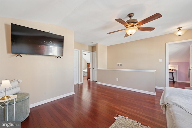living area with vaulted ceiling, hardwood / wood-style flooring, ceiling fan, baseboards, and visible vents